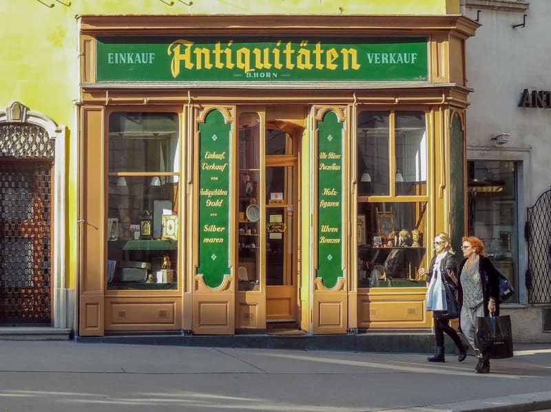 two women waling past an antique shop wile shopping - one of the things to do in Vienna