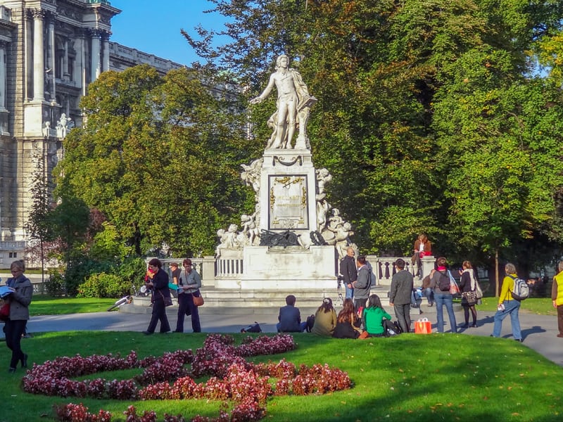 people in a park around a large statue