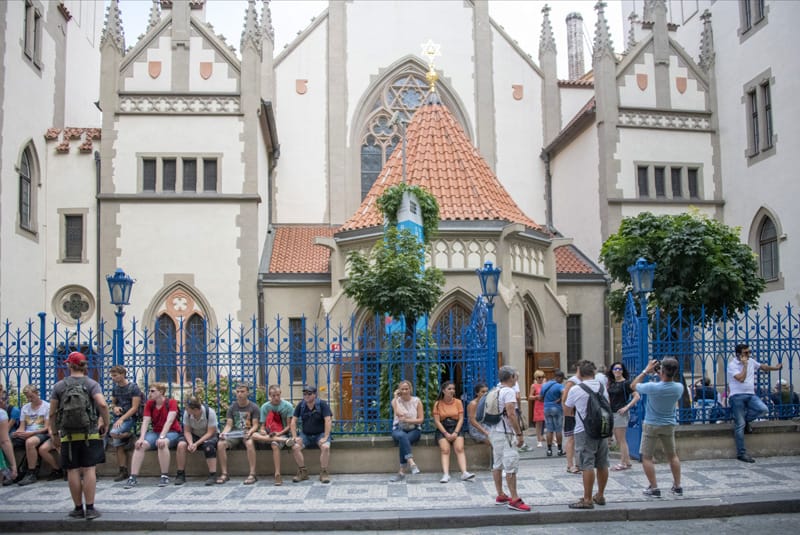 people sitting in front of a synagogue in Prague, one of the European sites for Jewish travelers