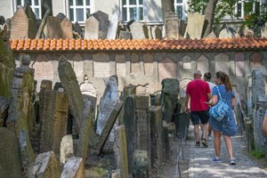 people walking through an old cemetery