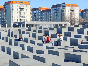 people sitting on large concrete blocks in a memorial