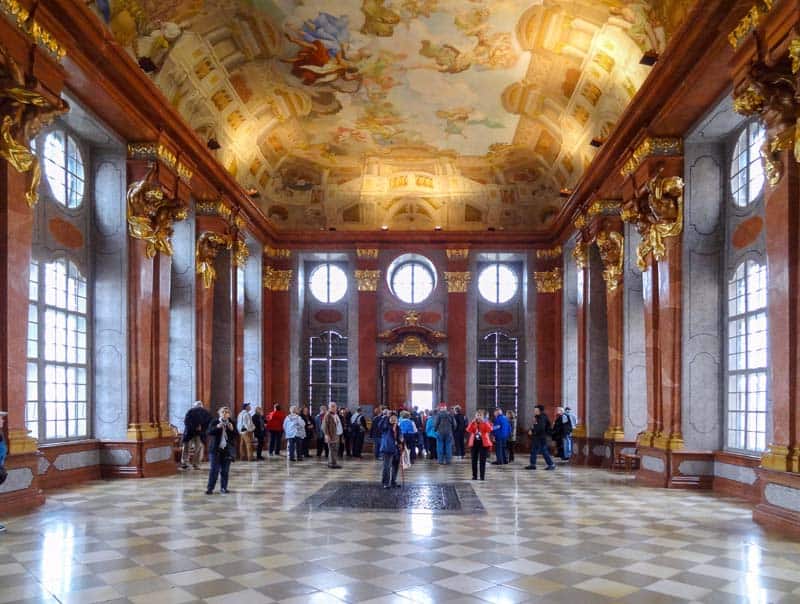 people in a large room with a painted ceiling in Melk Abbey