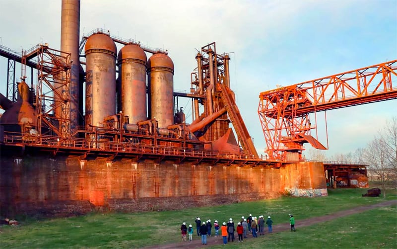 a group of people on a tour at a large industrial tourism site