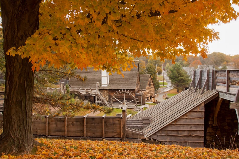trees in fall by old wooden buildings that are part of industrial tourism in the U.S.