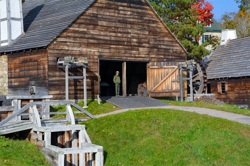 a park ranger standing in the entrance of an old wood building