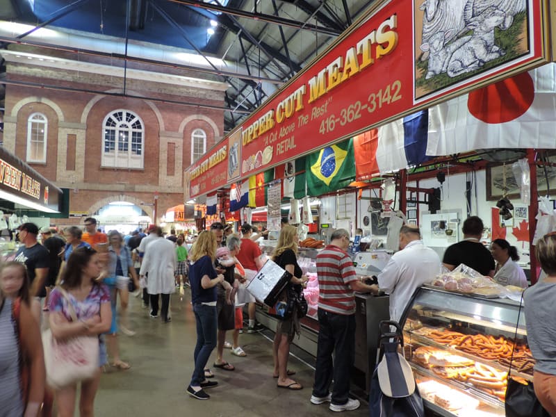 people at a butchers shop in a large market