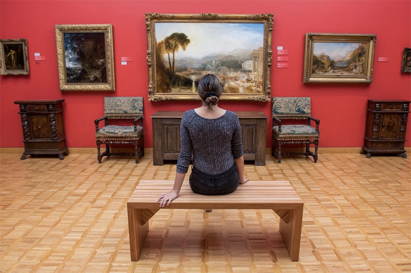 a woman looking at a painting in a museum in Fredericton New Brunswick