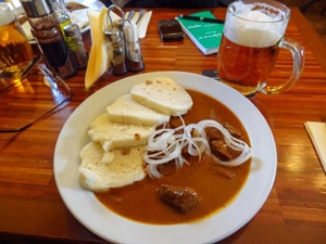 a bowl of Czech beef goulash and a beer stein