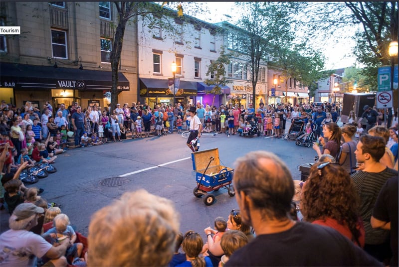 a crowd on a street looking at a festival performer in Fredericton New Brunswick