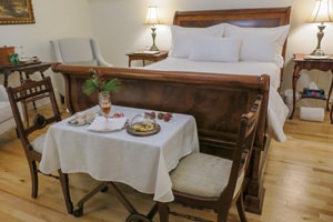 a small table with snacks and a glass of wine in a hotel bedroom in Fredericton New Brunswick