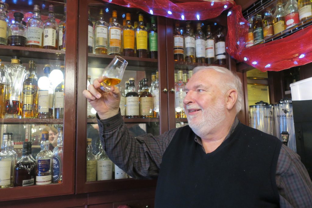 a man in a bar looking at a whisky glass in Fredericton New Brunswick
