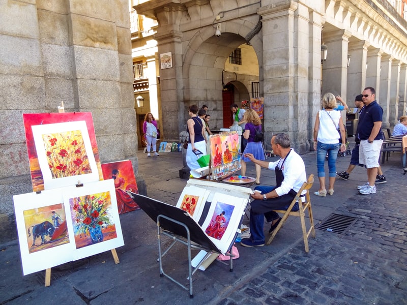 people watching artists in Plaza Mayor, one of the things to do in Madrid