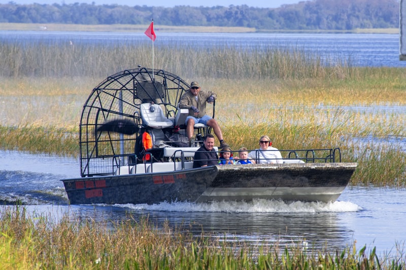 a couple with children on an airboat