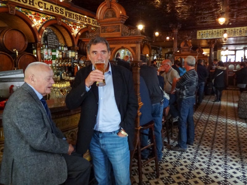A man drinking a beer in The Crown Liquor Saloon