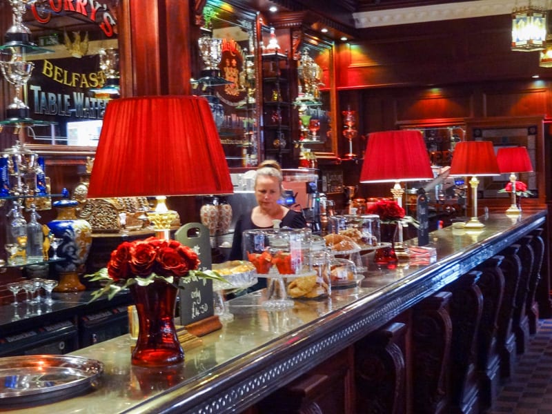 a woman behind the bar of the Dark Horse. Visiting it is on of the best things to do in Belfast