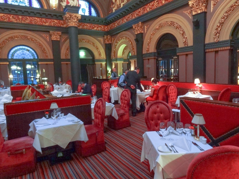 a room with red furniture in the Great Room Restaurant int the Merchant Hotel