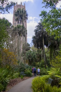 people walking through a garden with tall bushes and trees - one of the Things to Do in Orlando for Adults