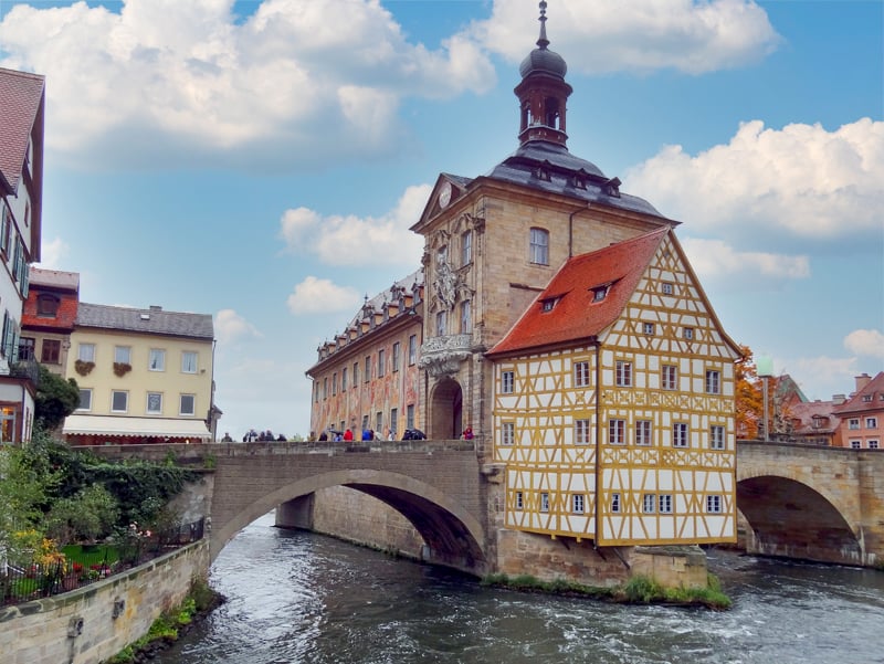 a bridge to an island with colorfully painted buildings in Bamberg Germany