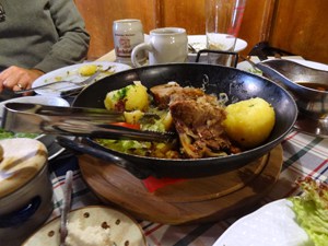 a skillet with meat and potatoes on a table