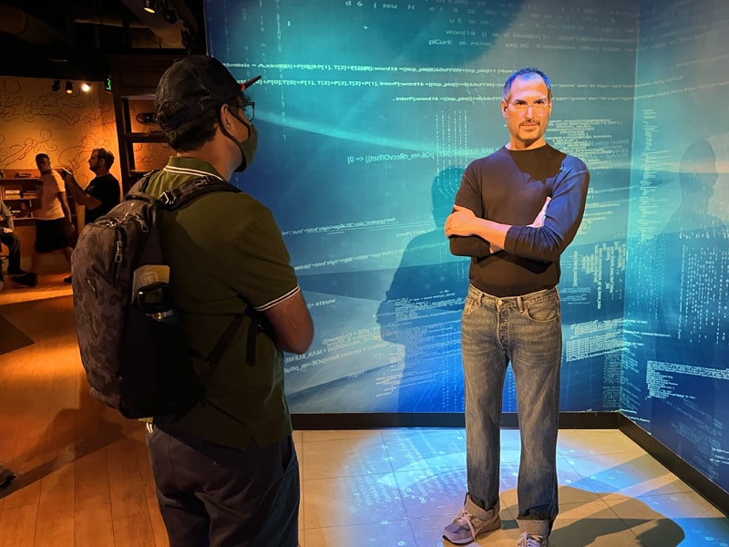 a man looking at a wax figure of Steve Jobs - one of the Things to Do in Orlando for Adults