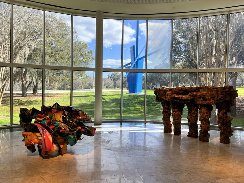 the view out of a large window at a large blue art sculpture