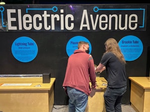 a couple by a sign saying Electric Avenue