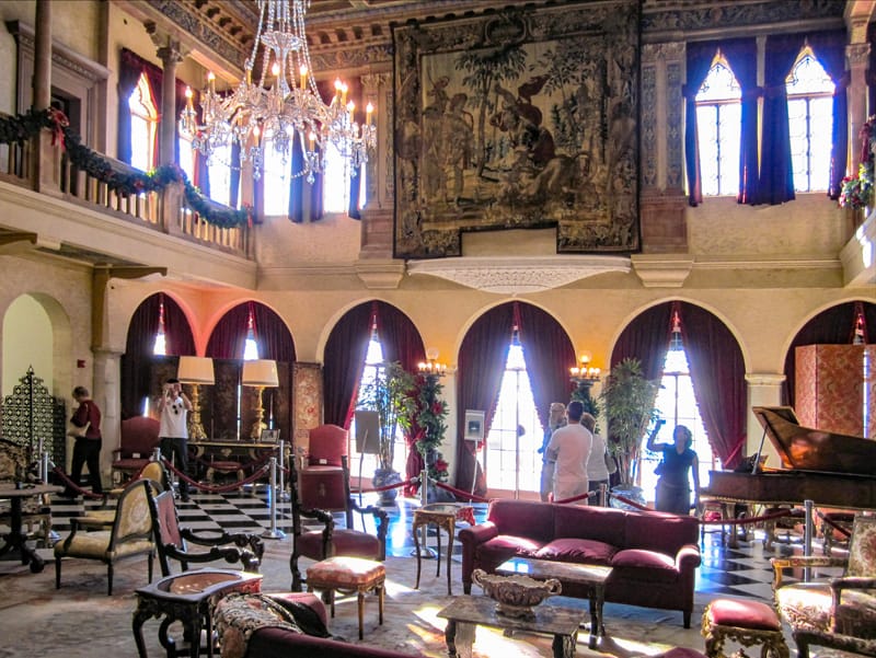 people in an ornate room with furniture and tapestries in the Ringling Museum