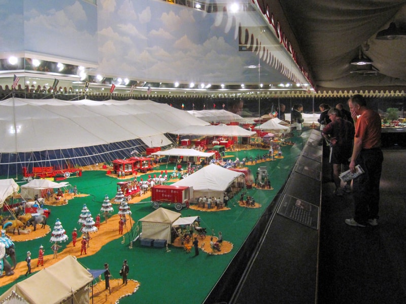 people looking at an exhibit of a miniature circus