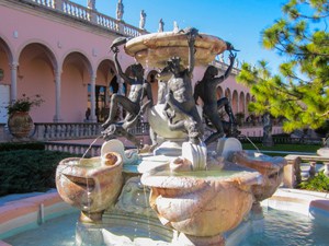 a fountain in front of a pink building