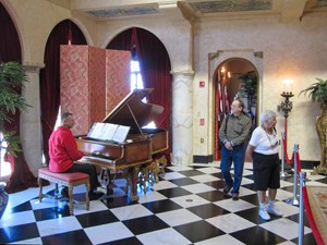 a many playing a piano in a large room