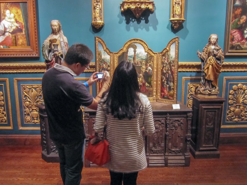 a couple taking a photo of religious art in a museum