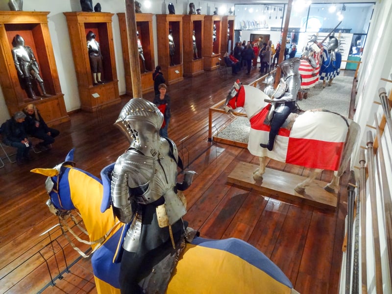 people in a museum looking at suits of armor