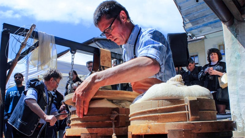 a man stacking wheels of cheese