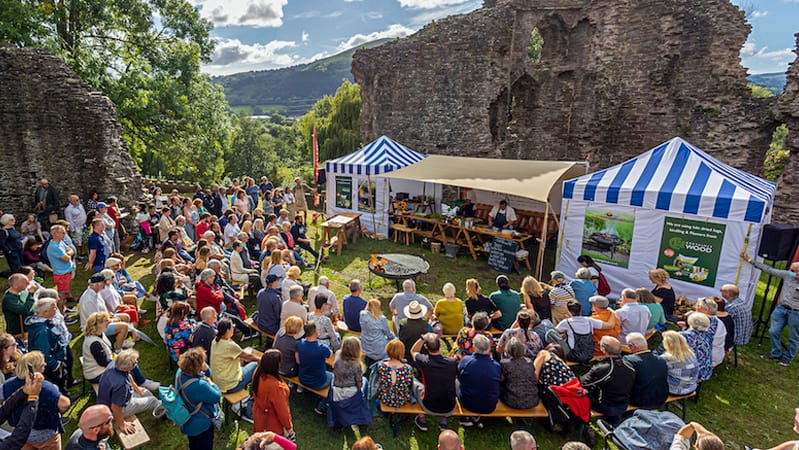 a crowd of people watch a chef demonstration at one of the food festivals in Europe 2023
