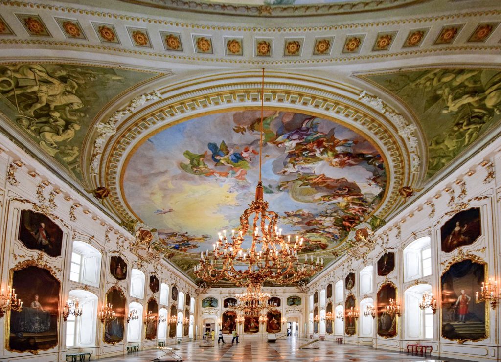 People visiting a great hall with a colorful fresco ceiling - one of the things to do in Innsbruck