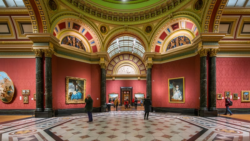 people looking at paintings in a museum - one of the free things to do in London