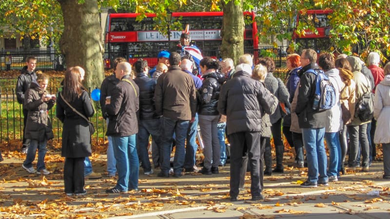 people in a park listening to a ma speaking - one of the free things to do in London