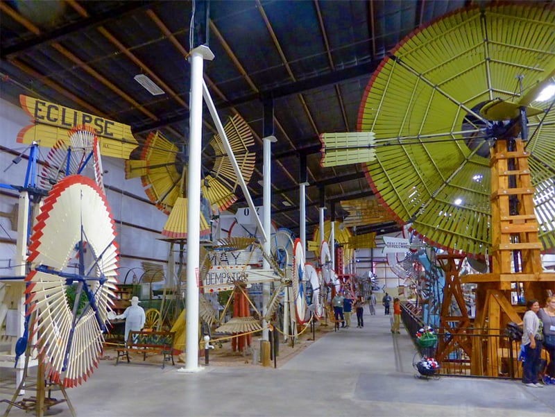 people walking through an exhibit of windmills in an unusual museum