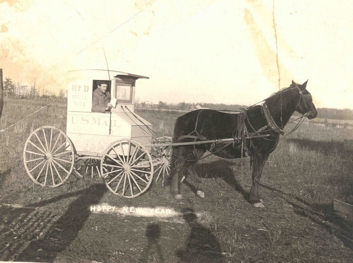 an old photo of a horsdrawn post-office carriage  in an unusual museum