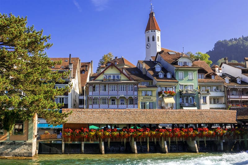 an old bridge and skyline of beautiful old buildings in Interlaken, one of the best places in Switzerland