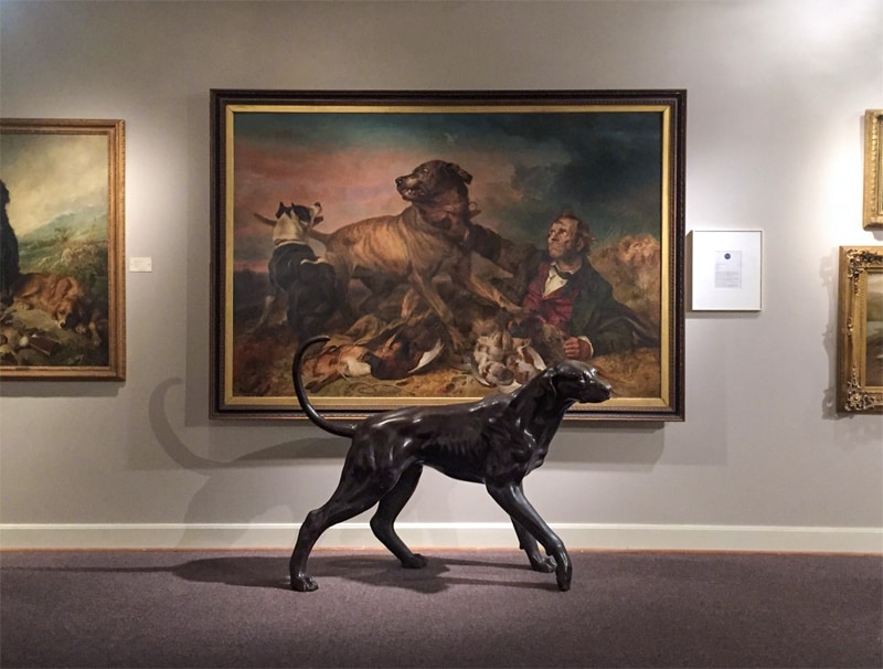 a statue and a painting of dogs in an unusual museum