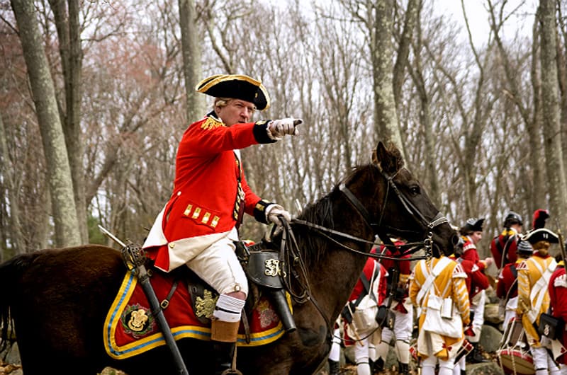 a British soldier in a red coat on a horse
