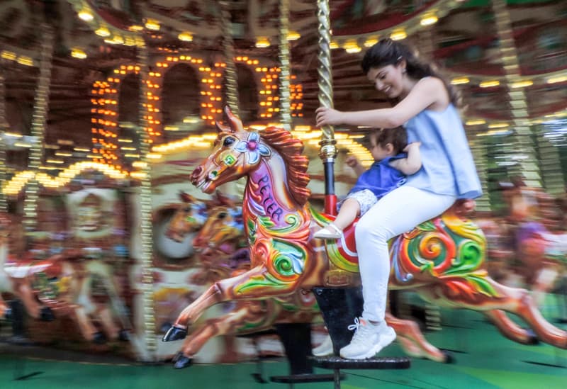 a woman and small child on a merry-go-round