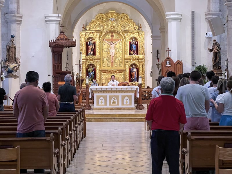 people attending mass in a cathedral