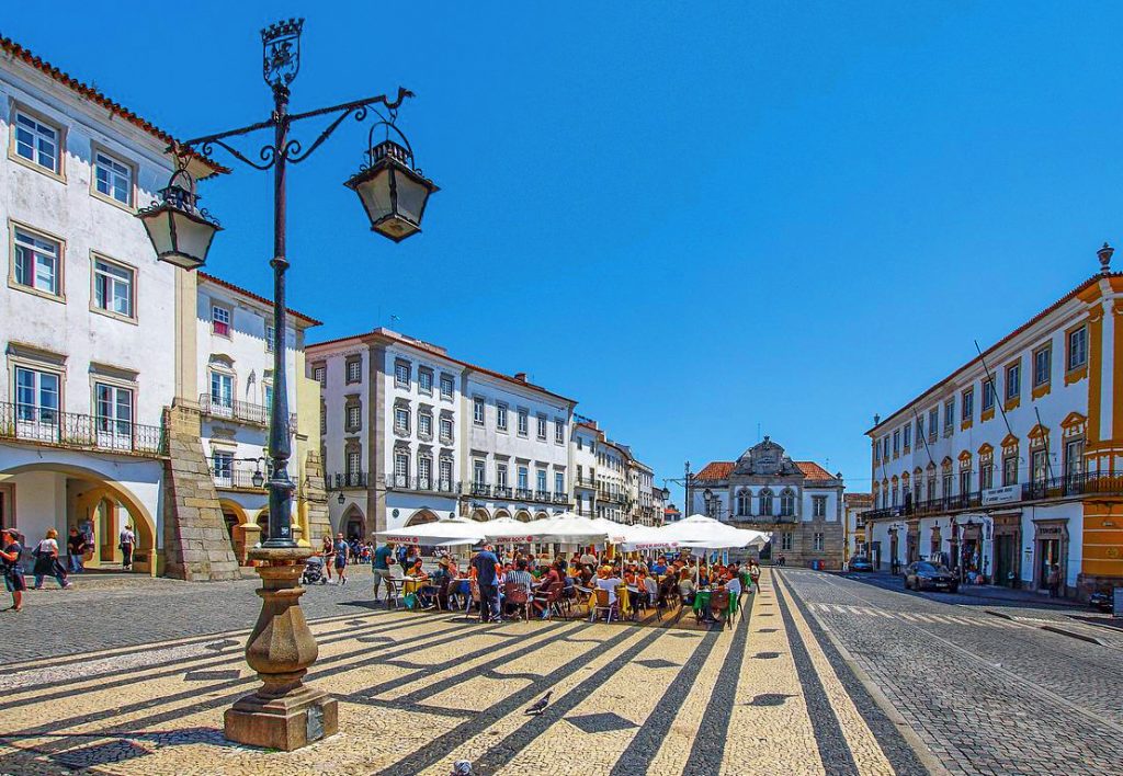 people sitting under a tent in a large city square