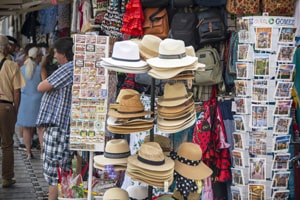 postcards and hats on a rack outside a shop