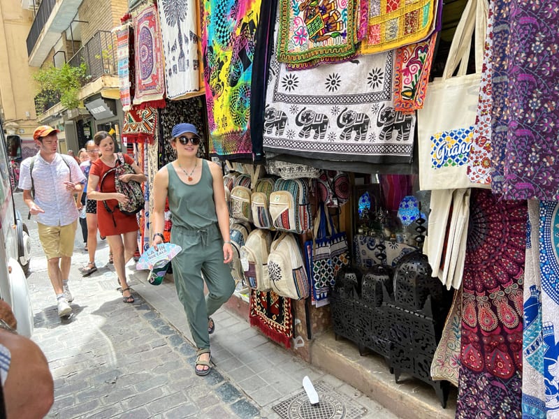 a woman walking along a street in a bazaar