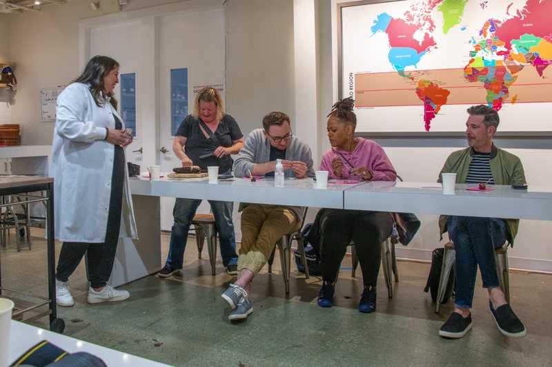 people sitting at a table examining chocolate in a chocolate factory in Seattle Southside