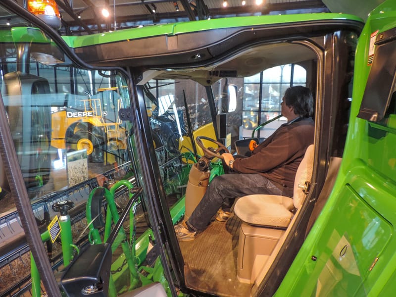 man-sitting-in-cab-of-giant-harvester