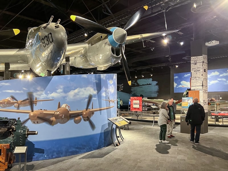 people standing beneath an airplane exhibit in a museum in Seattle Southside